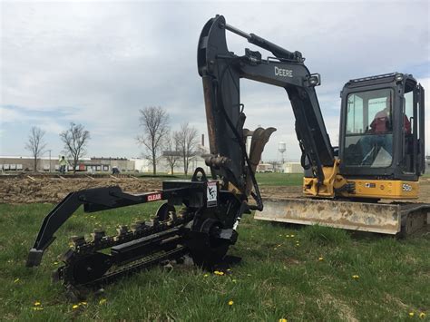 digging a trench with a skid steer|bobcat excavator trenching attachment.